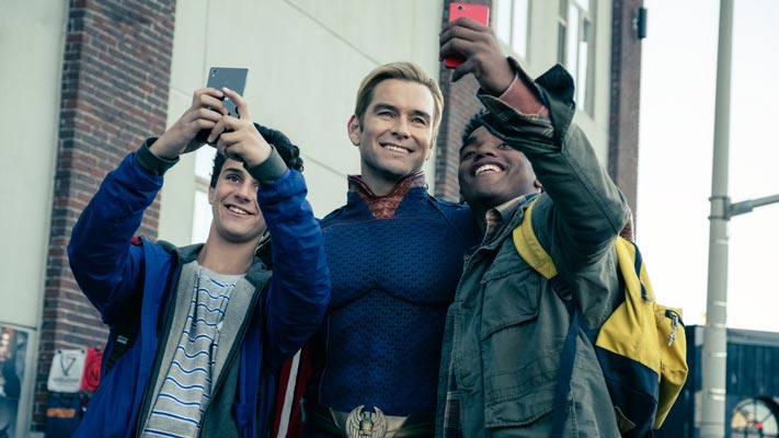 Homelander tirando selfies com dois jovens