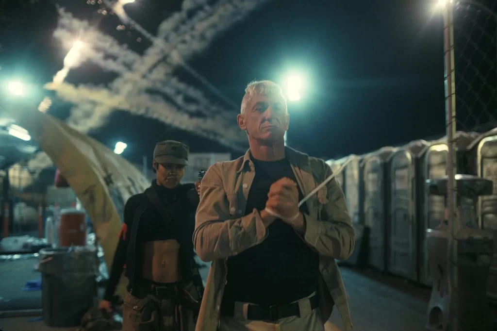 Coronel Steven J. Lockjaw (Sean Penn), rendido pela revolucionária Perfidia (Teyana Taylor) em Uma Batalha Após a Outra.