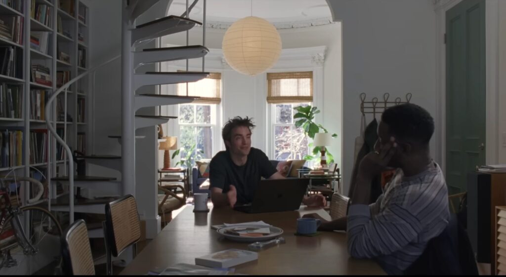 Charlie (Pattinson) escreve seu discurso de casamento com a ajuda de seu amigo Mike (Mamoudou Athie) em O Drama.